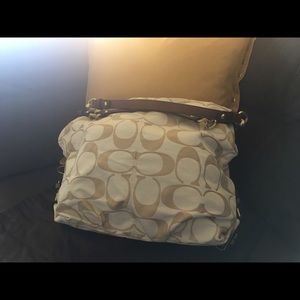 Medium size cream and tan Coach handbag.